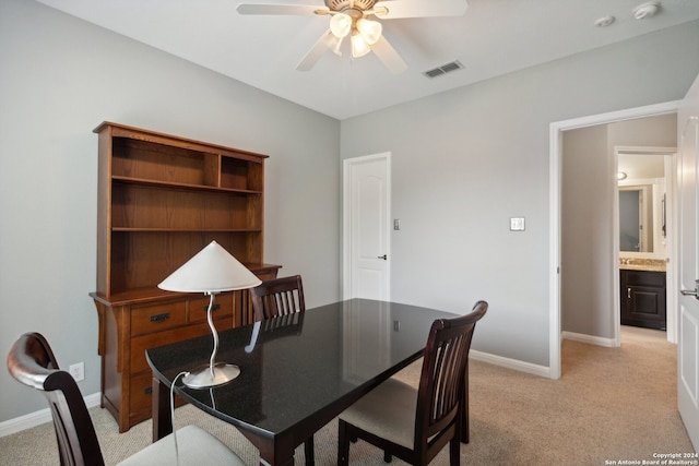 carpeted dining area with ceiling fan