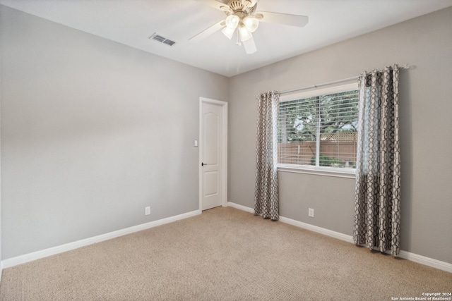 empty room featuring ceiling fan and light colored carpet