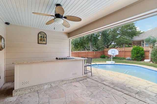 view of swimming pool with ceiling fan and a patio area