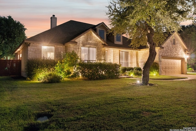 view of front of house with a garage and a lawn