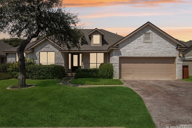 view of front of property featuring a lawn and a garage