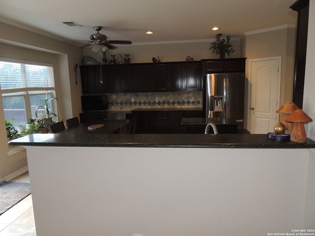 kitchen with ceiling fan, stainless steel refrigerator with ice dispenser, kitchen peninsula, and decorative backsplash