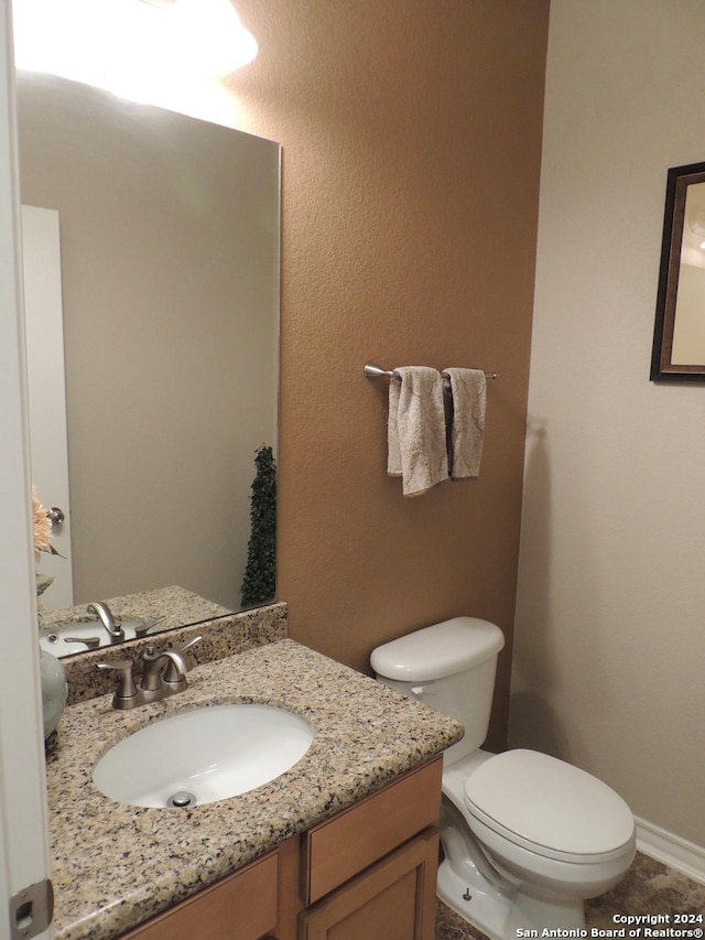 bathroom featuring tile patterned flooring, vanity, and toilet