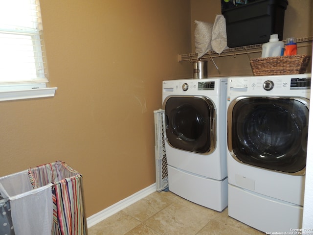 laundry area with light tile patterned flooring and washer and dryer