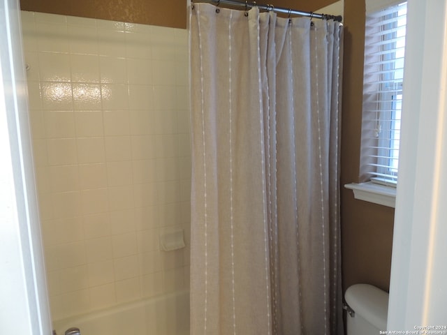 bathroom featuring shower / bath combo and toilet