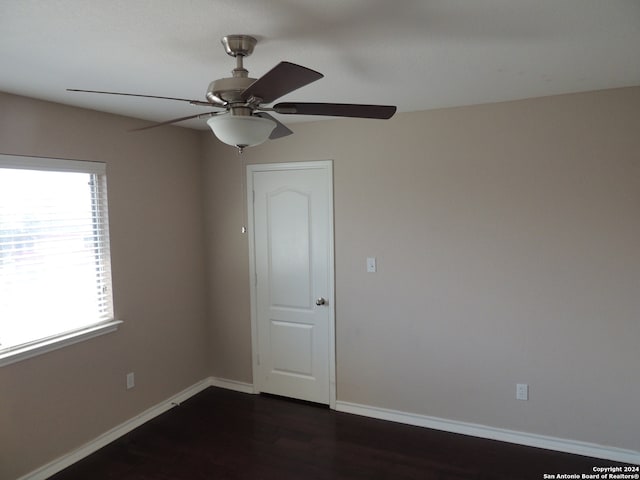 unfurnished room with ceiling fan and dark hardwood / wood-style flooring