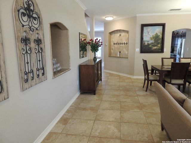 interior space featuring crown molding and light tile patterned floors