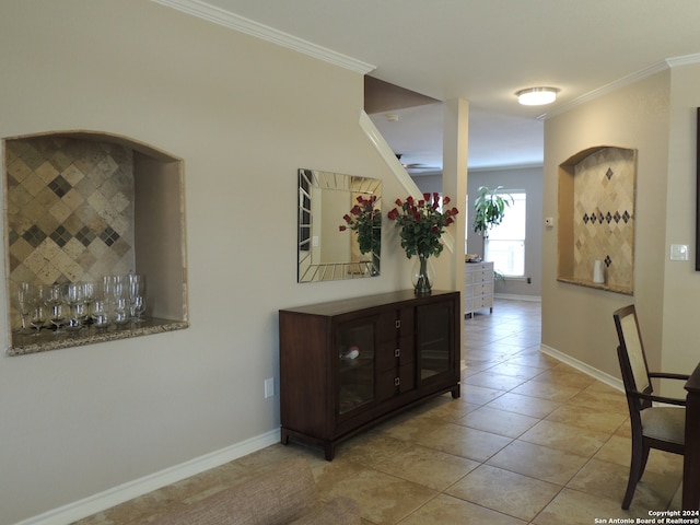 tiled entrance foyer featuring crown molding