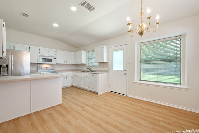 kitchen featuring hanging light fixtures, white appliances, vaulted ceiling, and white cabinetry