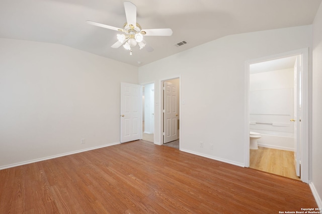 unfurnished bedroom featuring wood-type flooring, vaulted ceiling, connected bathroom, and ceiling fan