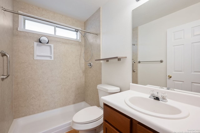 bathroom featuring tiled shower, vanity, and toilet