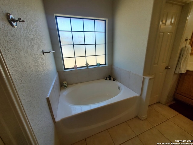 bathroom with tile patterned flooring and a washtub