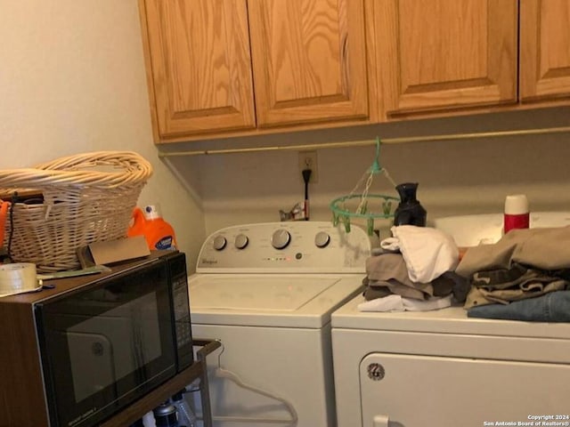 laundry area with washing machine and clothes dryer and cabinets