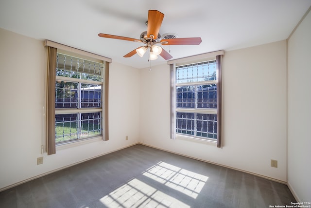 carpeted spare room with ceiling fan and a wealth of natural light