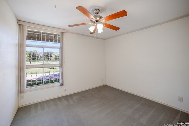 empty room with ceiling fan and dark carpet