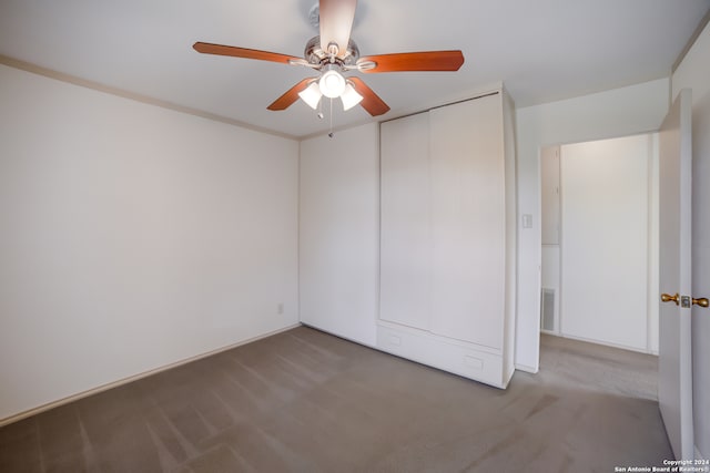 unfurnished bedroom featuring ceiling fan, a closet, and carpet flooring