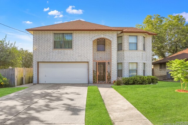 view of property with a garage and a front lawn