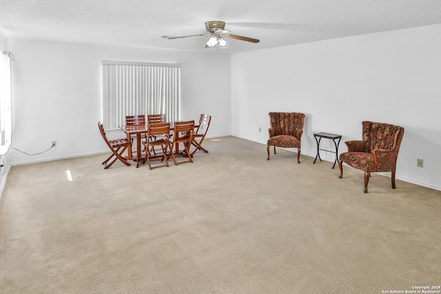 carpeted dining area with ceiling fan