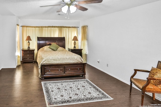 bedroom with a textured ceiling, ceiling fan, and dark hardwood / wood-style flooring