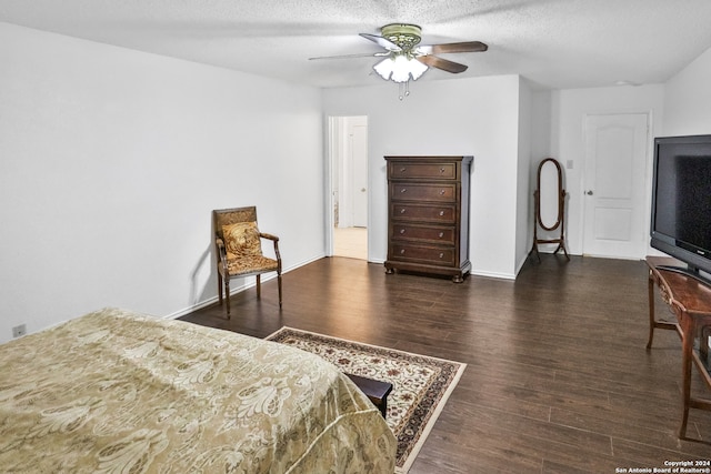 bedroom featuring ceiling fan, dark hardwood / wood-style floors, and a textured ceiling