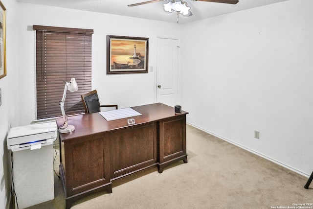 carpeted office space with ceiling fan