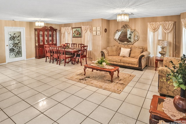 living room with a textured ceiling, light tile patterned flooring, and an inviting chandelier