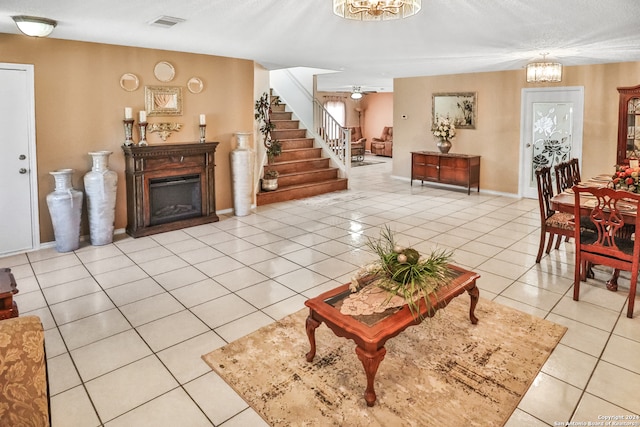 tiled living room featuring a textured ceiling and a chandelier