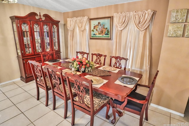 dining area with a textured ceiling and light tile patterned flooring