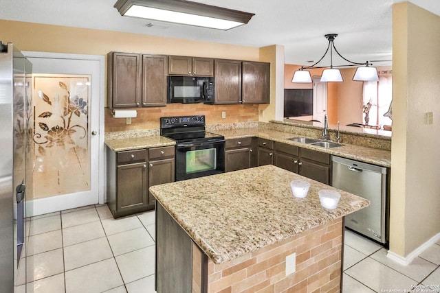 kitchen featuring dark brown cabinets, light stone counters, sink, a kitchen island, and black appliances