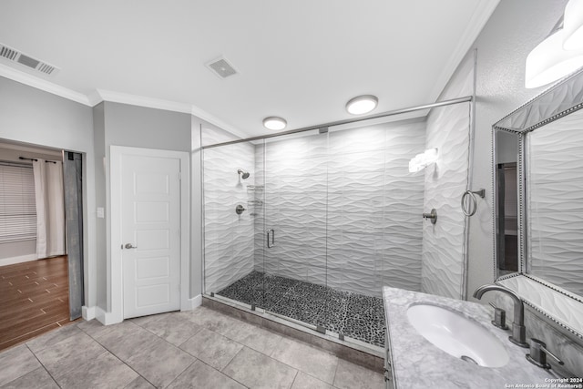 bathroom featuring ornamental molding, hardwood / wood-style floors, vanity, and a shower with shower door