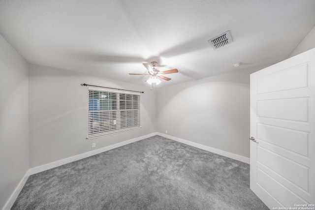 empty room featuring ceiling fan and carpet