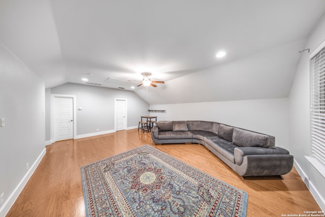 living room featuring ceiling fan, light wood-type flooring, and vaulted ceiling