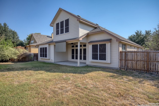 rear view of property featuring a lawn and a patio area