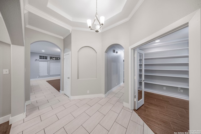 hall featuring crown molding and a notable chandelier