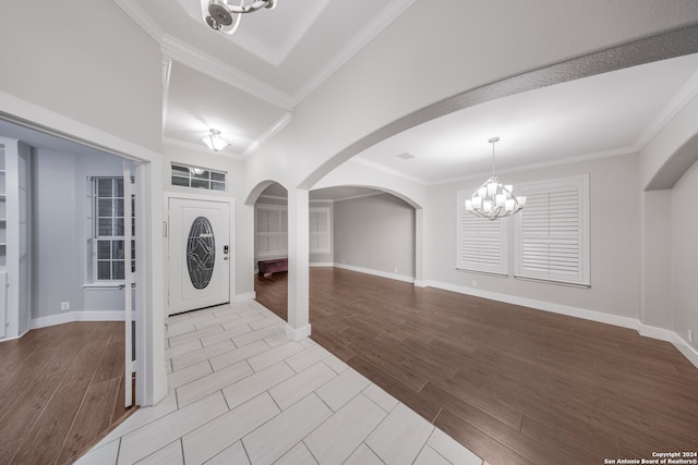 interior space with a notable chandelier, light hardwood / wood-style flooring, and ornamental molding