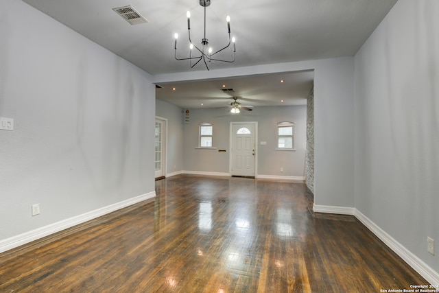 interior space with ceiling fan with notable chandelier and dark wood-type flooring