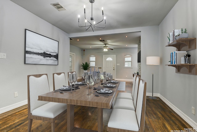 dining space featuring ceiling fan with notable chandelier and dark wood-type flooring