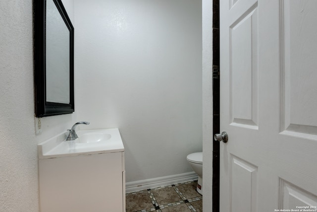 bathroom featuring tile patterned flooring, vanity, and toilet