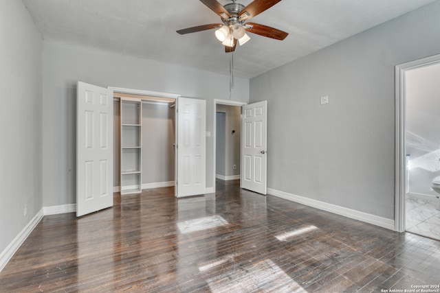 unfurnished bedroom with a closet, ensuite bath, ceiling fan, and dark hardwood / wood-style flooring