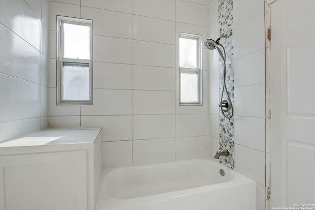 bathroom with tiled shower / bath and a healthy amount of sunlight