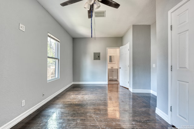 spare room with electric panel, ceiling fan, and dark hardwood / wood-style floors