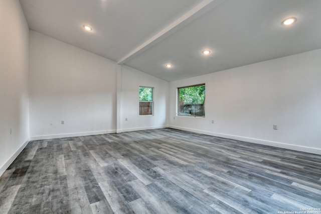 spare room with vaulted ceiling with beams and dark hardwood / wood-style floors