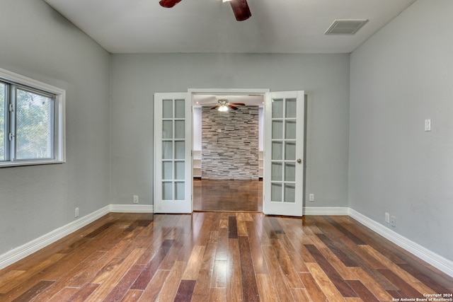 spare room with dark hardwood / wood-style floors, ceiling fan, and french doors