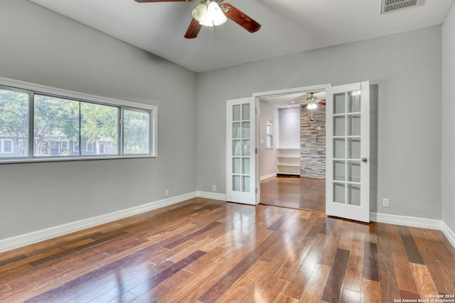 empty room featuring french doors, hardwood / wood-style floors, and ceiling fan