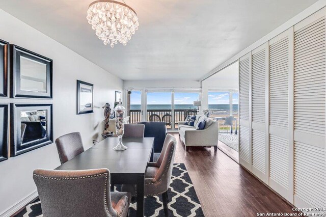 dining area with an inviting chandelier, plenty of natural light, and dark wood-type flooring