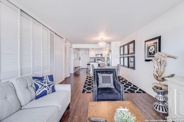 living room with a notable chandelier and dark wood-type flooring