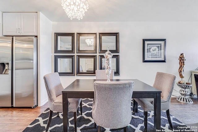 dining space with light wood-type flooring and an inviting chandelier