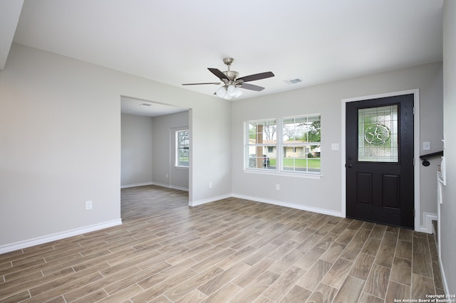 foyer entrance featuring ceiling fan, light wood-type flooring, and a healthy amount of sunlight