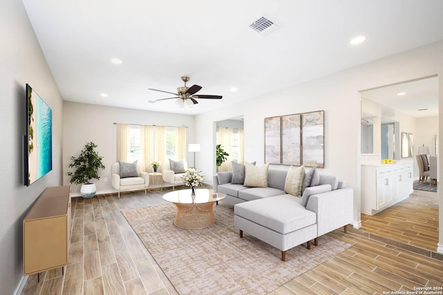 living room featuring light hardwood / wood-style flooring and ceiling fan