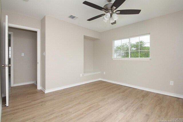 bedroom with a closet, ceiling fan, a walk in closet, and hardwood / wood-style flooring